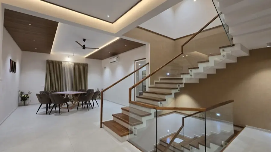 Dining area beside the glass-railed timber staircase